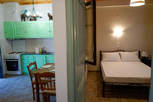 VavkeríにあるKantounia Stonehouseのベッド1台付きの部屋、テーブル付きのキッチンが備わる客室です。