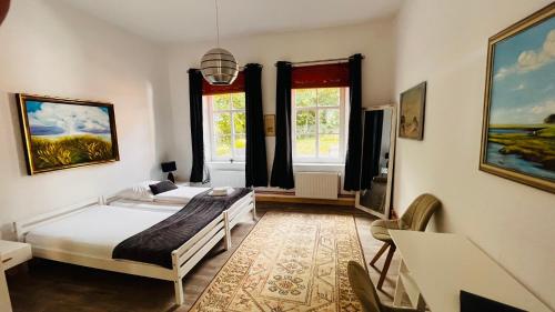 a bedroom with two beds and two windows at Ferienhaus Alte Schule Niebüll in Niebüll