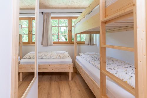 two bunk beds in a room with a window at Planinska koča na Uskovnici in Srednja Vas v Bohinju