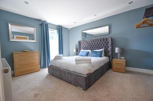 a bedroom with a large bed with blue walls at Birchwood in Skegness in Skegness