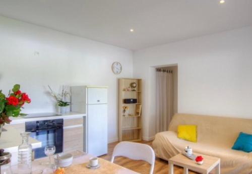 un salon avec un canapé et une table dans l'établissement Appartement tranquille en bas de villa, à Afa