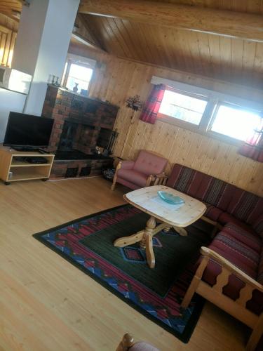 a living room with a table and a couch at Toppen in Flatåker