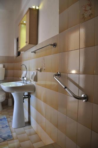 a bathroom with a sink and a toilet and a mirror at House Margot in Palekastron