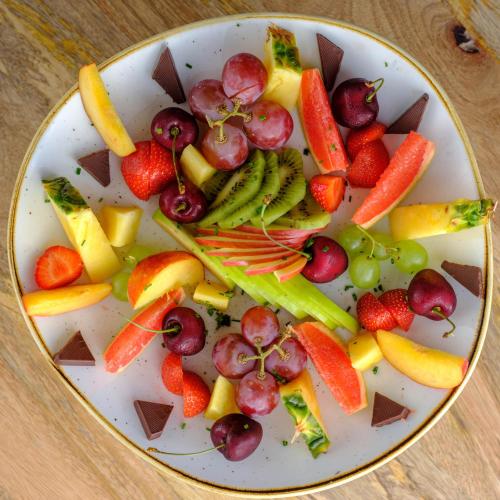 a plate of fruit and vegetables on a table at Acro Blue Luxury Villas in Akrotiri