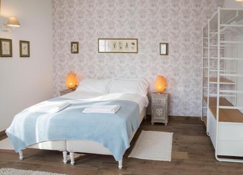 una camera con un letto, due lampade e una mensola di Villa del Tempo a Desenzano del Garda