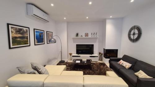 a living room with a couch and a tv at The Poolside Bliss in San Ġwann