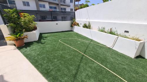 a backyard with a lawn with a hose on it at The Poolside Bliss in San Ġwann