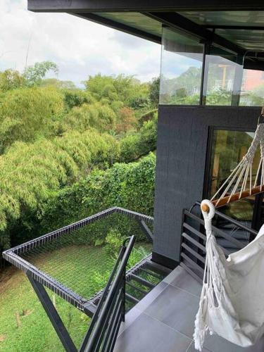 a hammock on a balcony with a view of a forest at Entre Bambús in Pereira