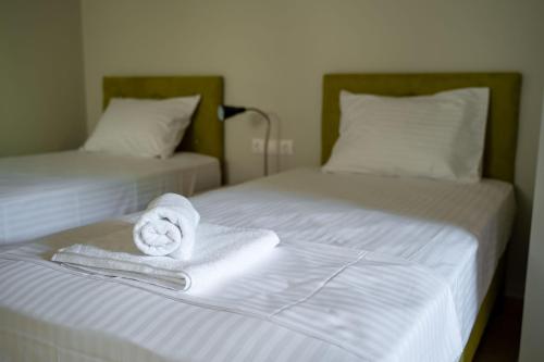 two beds with towels sitting on top of them at Armonia Studios Preveza in Preveza