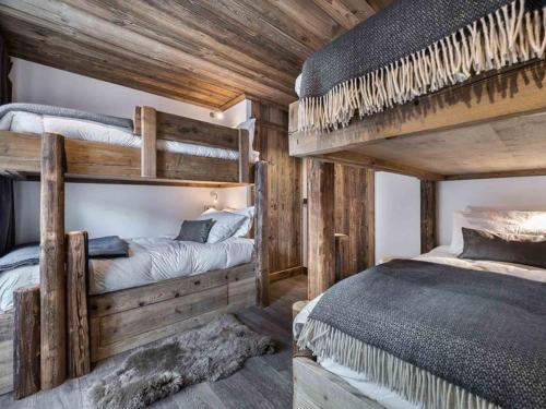 Ce lit se trouve dans un dortoir doté de 2 lits superposés et de murs en bois. dans l'établissement Duplex luxueux 10p avec cheminée, 500m des pistes à Val d'Isère - FR-1-567-11, à Val dʼIsère