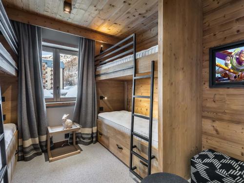a bedroom with bunk beds in a log cabin at Appartement spacieux, cosy avec cheminée, proche pistes et école de ski, idéal pour familles - FR-1-567-12 in Val dʼIsère