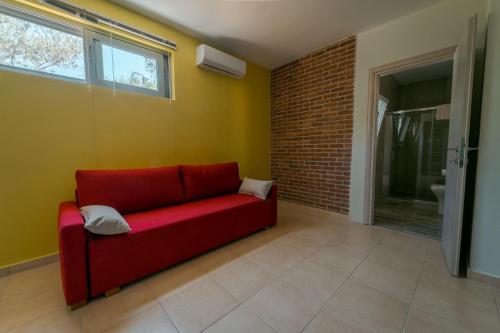 a red couch in a room with a brick wall at Armonia Studios Preveza in Preveza