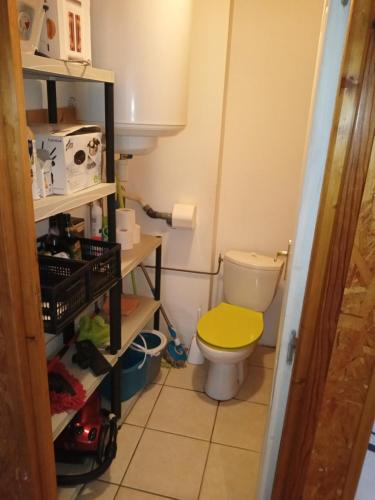La salle de bains est pourvue de toilettes et d'un couvercle jaune. dans l'établissement appartement meublé, à Vizille