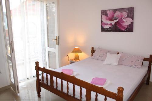 een slaapkamer met een bed met roze handdoeken bij Apartments Iris in Herceg-Novi
