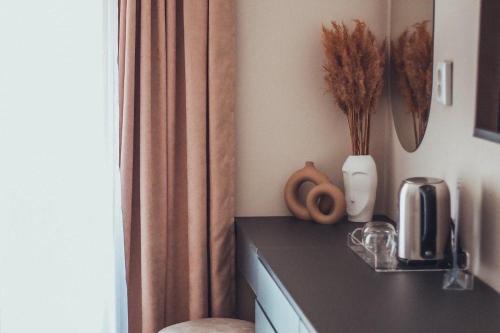 a kitchen with a counter top with a vase with flowers at VIP apartments Bitola in Bitola