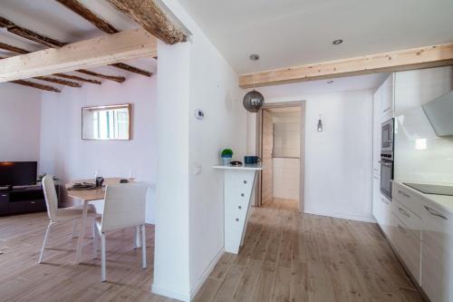 a kitchen and dining room with white walls and wooden floors at Acqua - by MyHomeinComo in Moltrasio