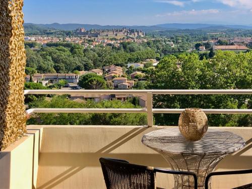 un tavolo e sedie su un balcone con vista di Panorama Suite romantique & Spa a Carcassonne
