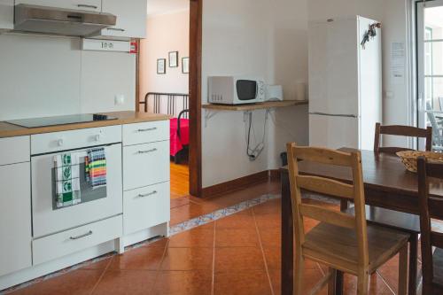 a kitchen with a table and a dining room at Casal dos Cantos in Quinta do Anjo