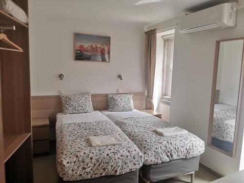 um quarto com 2 camas e um espelho em City Inn em Lisboa