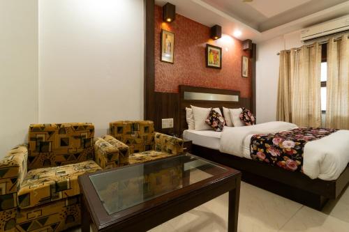 Habitación de hotel con 2 camas y mesa de cristal. en Hotel Baba Deluxe -By RCG Hotels en Nueva Delhi