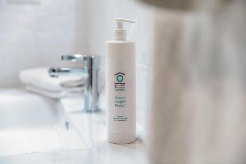 a white bottle of lotion sitting next to a sink at Acqua - by MyHomeinComo in Moltrasio