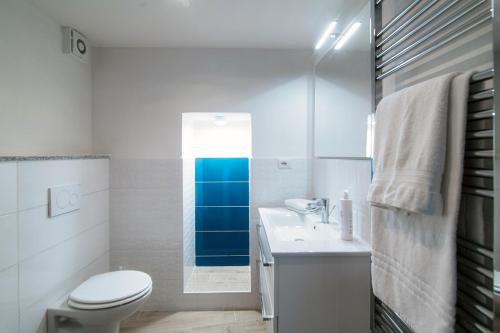 a white bathroom with a toilet and a sink at Acqua - by MyHomeinComo in Moltrasio