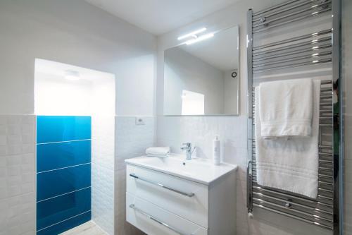 a white bathroom with a sink and a mirror at Acqua - by MyHomeinComo in Moltrasio