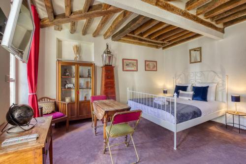 a bedroom with a bed and a table and chairs at Charme de l'ancien aux portes de Paris ! in Charenton-le-Pont