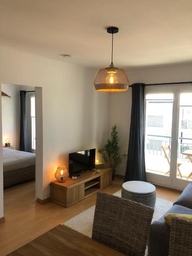 - un salon avec une télévision, un lit et un canapé dans l'établissement DEMOISELLES - Appartement 1 chambre, à Saint-Jean-de-Monts