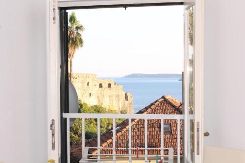 een open deur naar een balkon met uitzicht op een kasteel bij Apartments Iris in Herceg-Novi