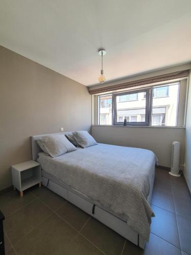 a bedroom with a large bed with a window at stevans place in Bredene