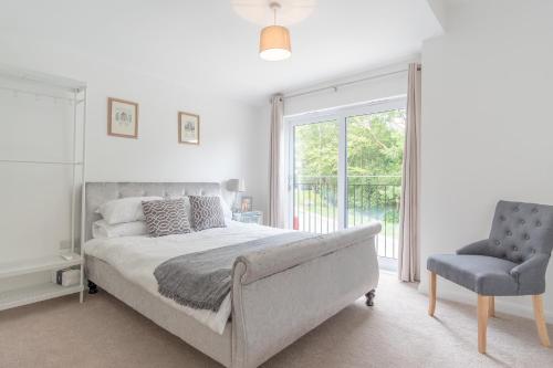 a bedroom with a bed and a chair and a window at Snowdon Holiday Let, brand new home in the heart of Llanberis in Llanberis