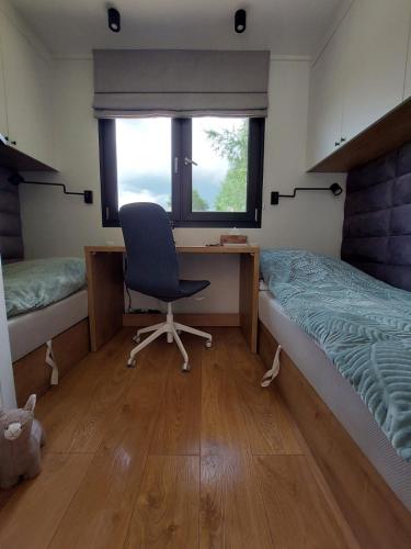 a bedroom with a desk and a chair next to a bed at Ekolandia in Orneta