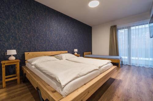 a bedroom with a large bed with white sheets at Adalbert penzion Čejkovice in Čejkovice