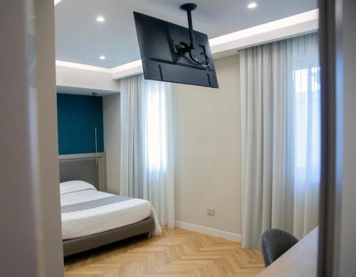a bedroom with a bed and a tv hanging from the ceiling at Hotel Ristorante Aeclanum in Mirabella Eclano