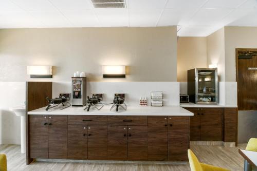 a kitchen with wooden cabinets and a counter top at Beachfront Palms Hotel Galveston in Galveston