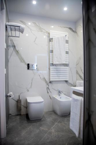 a white bathroom with a toilet and a sink at Hotel Ristorante Aeclanum in Mirabella Eclano