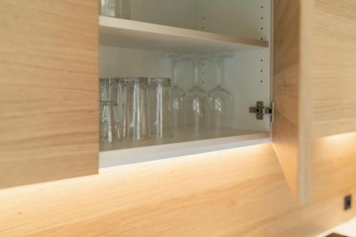 a cupboard with many glass vases in it at VANEA - Alp Relax Guesthouse in Chienes
