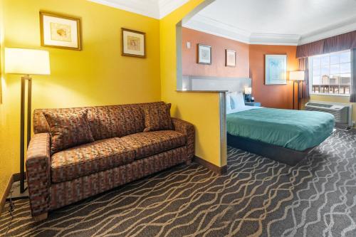 a hotel room with a couch and a bed at Quality Inn & Suites Galveston - Beachfront in Galveston