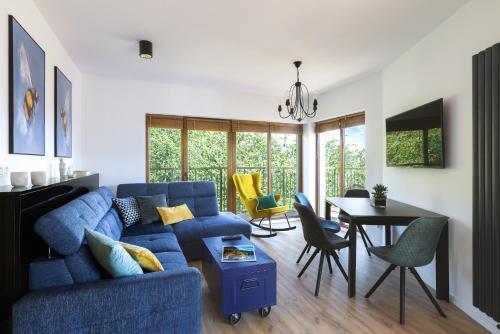 un salon avec un canapé bleu et une table dans l'établissement Słoneczny apartament z widokiem na góry, à Szklarska Poręba