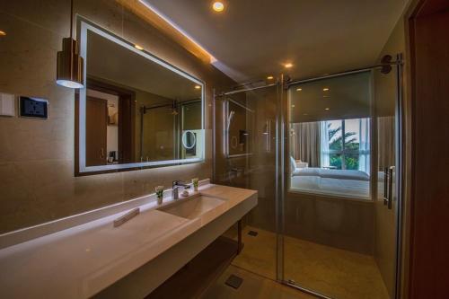 a bathroom with a sink and a glass shower at Luxotel Aqaba Beach Resort & Spa Only 15 years plus in Aqaba