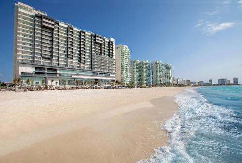 a beach with tall buildings and the ocean at Royalton CHIC Cancun, An Autograph Collection All-Inclusive Resort - Adults Only in Cancún