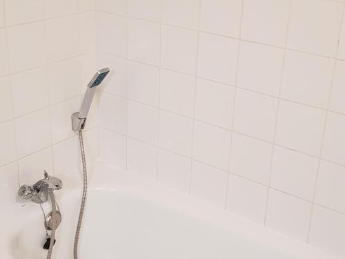 une douche avec pommeau de douche dans une salle de bain dans l'établissement Chalet Mitoyen 3 Pièces avec Local Ski et Parking Gratuit - FR-1-504-3, à Saint-Étienne-en-Dévoluy