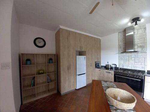 a kitchen with a table and a white refrigerator at Het Kadootje - Southbroom's little gift - 6 sleeper 3 bedroom apartment in Southbroom