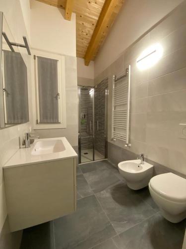 a bathroom with two sinks and a toilet and a shower at La Quercia in Cavallino-Treporti