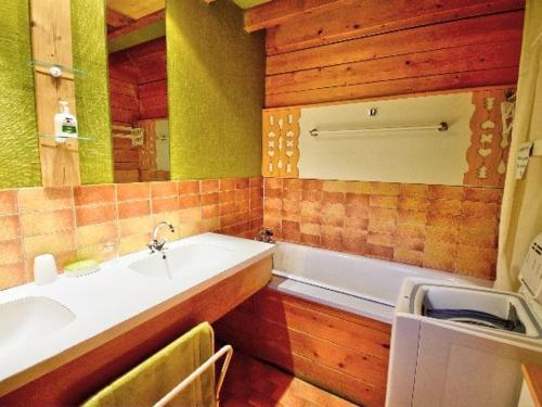 une salle de bain avec un lavabo et une baignoire dans l'établissement Chalet indépendant avec navettes gratuites, parking et cuisine équipée - FR-1-524-17, à Morzine