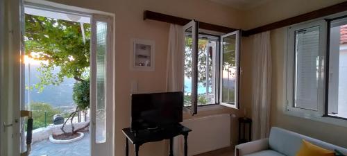 a living room with a tv and two windows at Golden Sunset in Angón