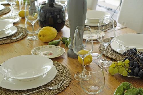 a wooden table with plates and wine glasses on it at Villa Dolce Bellezza in Salò