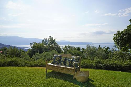 a bench in the grass with a view of the water at Villa Dolce Bellezza in Salò