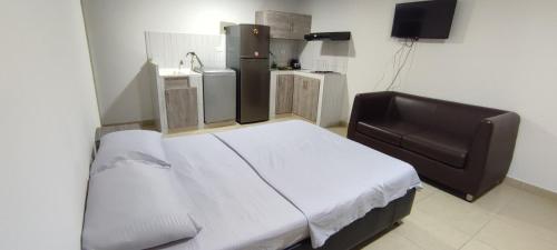 1 dormitorio con 1 cama grande y nevera en Espectacular Loft Tipo Smart San Alonso, en Bucaramanga